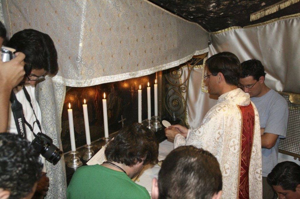 Armenian Priest leading a prayer group in the Grotto of the Nativity